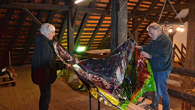 Heidrun Huying und Joachim Lauer in ihrer Scheune mit dem von Künstlerin Bettina Mauel bemalten Plastikvorhang. Foto: Christiane Sahli