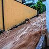 Braune Wassermassen rauschen am Abend des 28. Juni 2021 über eine Treppe nach unten nach heftigen Unwettern in Altensteig.