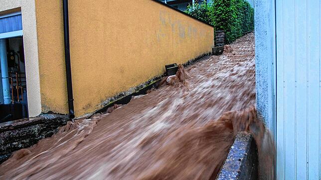 Braune Wassermassen rauschen am Abend (28. Juni) über eine Treppe nach unten nach heftigen Unwettern in Altensteig.