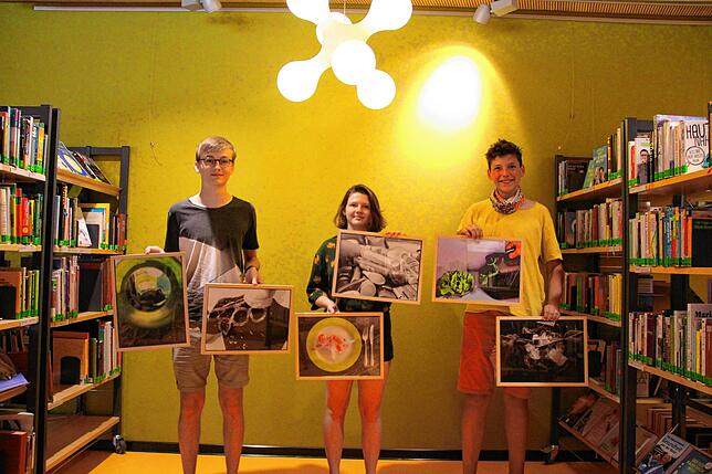 Die drei Schüler Marvin Würth (von links), Delia Herbstritt und Felix Köhler zeigen Bilder aus der Ausstellung.