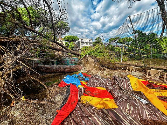 Planen und umgestürzte Bäume liegen nach einem Unwetter auf einem Platz des Badeortes.