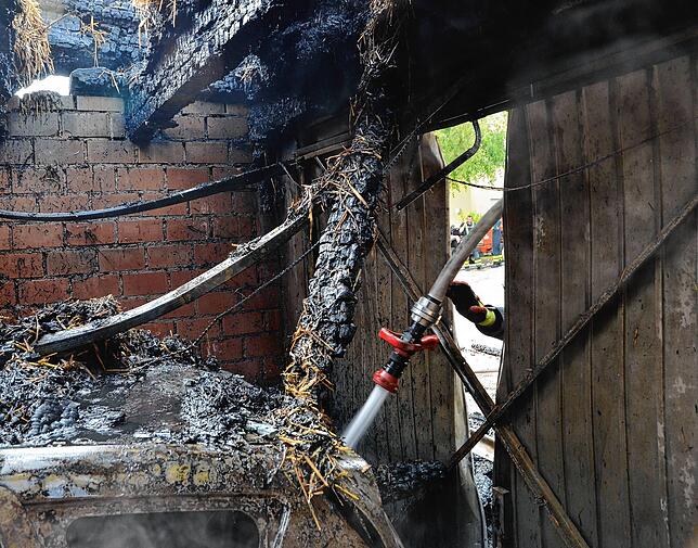 Im Inneren der Scheune gilt es, weiterer Brandentwicklung vorzubeugen.