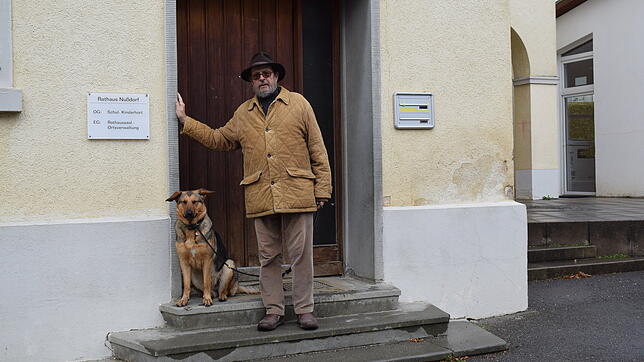Der Nußdorfer Ortsvorsteher Dietram Hoffmann mit Hund vor der Ortsverwaltung. Hoffmann tritt erneut zur Wahl an.