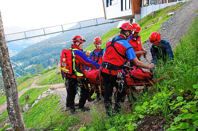 Die Verunglückte liegt auf einer Gebirgstrage, betreut von den Helfern. Mit einem Flasschenzugsystem wird die Trage nach oben gezogen.