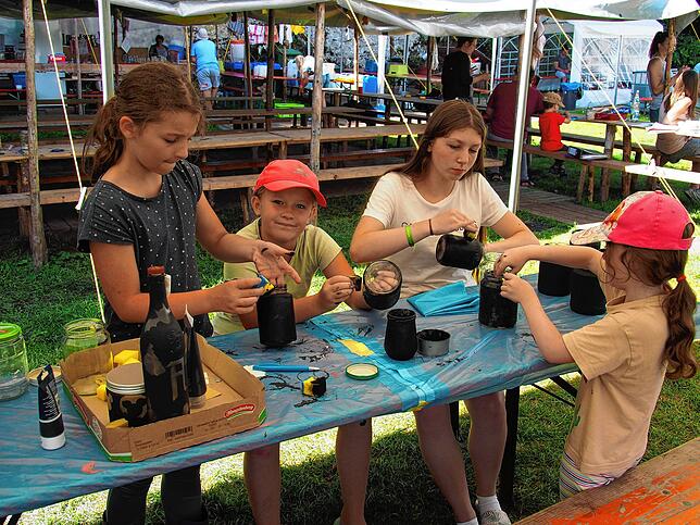 Das Schwärzen der Gläser macht zwar schmutzige Hände, aber den Kindern im Sommerlager viel Spaß.