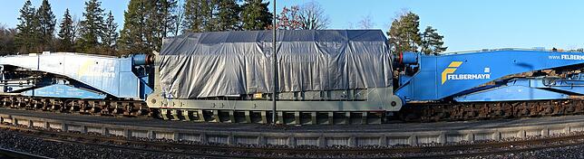 Der Hochspannungstransformator (mit Plane überdeckt) wiegt 300 Tonnen, wird in einen speziellen Schnabelwagen (benannt nach den beiden ...