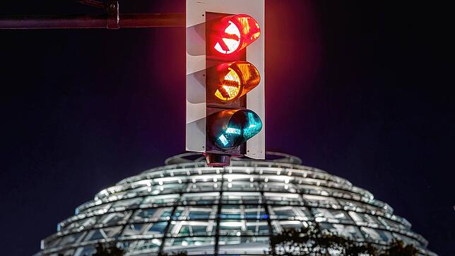 Eine Ampel vor der Kuppel des Reichstagsgebäudes leuchtet in einer Langzeitbelichtung in allen drei Phasen. SPD, Grüne und FDP beginnen ...