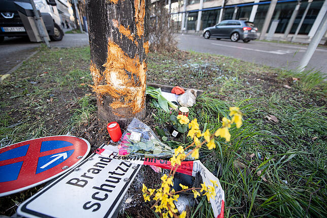 Blumen und Grablichter liegen an der Unfallstelle in der Rosensteinstraße in Stuttgart.