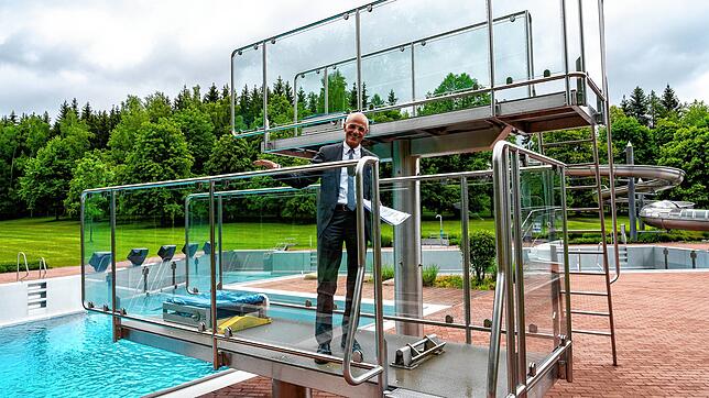 Königsfeld Bürgermeister Fritz Link demonstriert, wie die Handläufe am Sprungturm regelmäßig desinfiziert werden müssen. An den Regeln ...