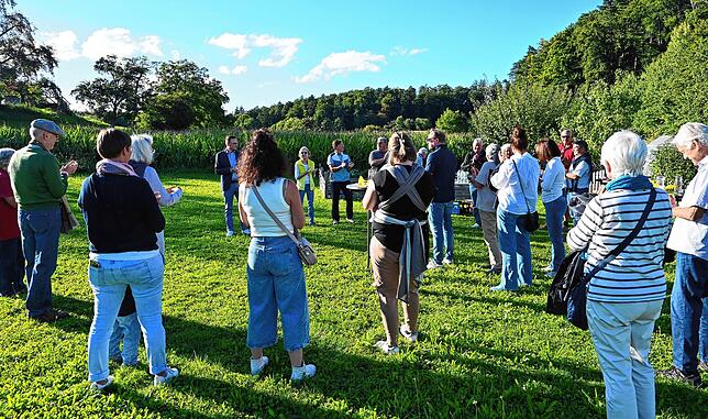 Manuel Strasser begrüßt seine Unterstützer und interessierte Bürger beim „Wiesen-Treffen“ am Waldweg. Etwa 35 Personen sind gekommen.