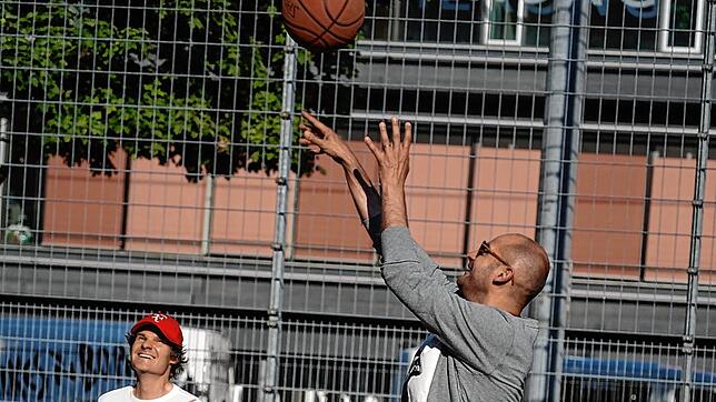 Grünen-Politiker Danyal Bayaz (rechts) wirft auf einem Basketballplatz in Stuttgart den Ball Richtung Korb. Links neben ihm ...