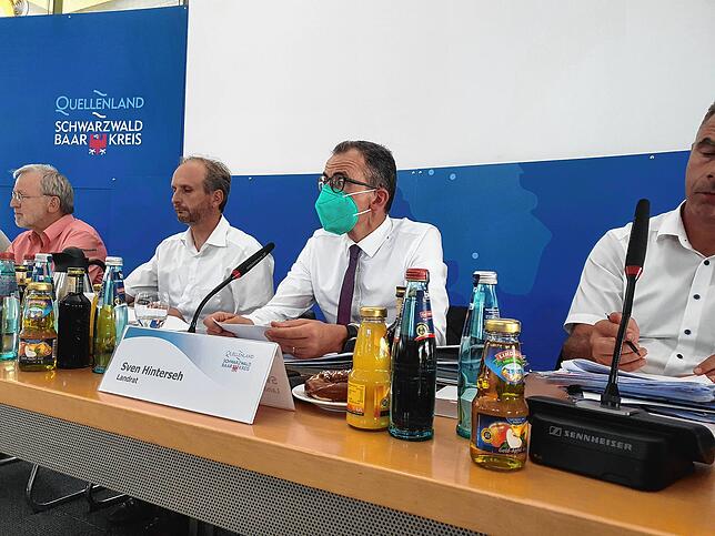 Landrat Hinterseh leitet die Kreistagssitzung mit Maske. Sein Tonfall erklärt die Maßnahme.