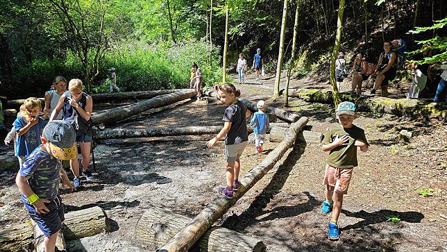 Gar nicht so leicht, auf einem Baumstamm zu laufen: Die Erfahrung machen die Kinder bei der Station Balancierbalken.