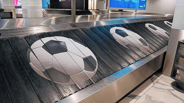 Riesenfußbälle auf dem Gepäckband am Euroairport.