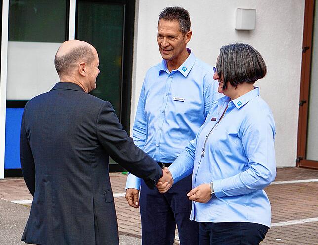 Klaus Segelbacher und Alexandra Moosherr vom VfB Friedrichshafen heißen Kanzler Olaf Scholz willkommen.