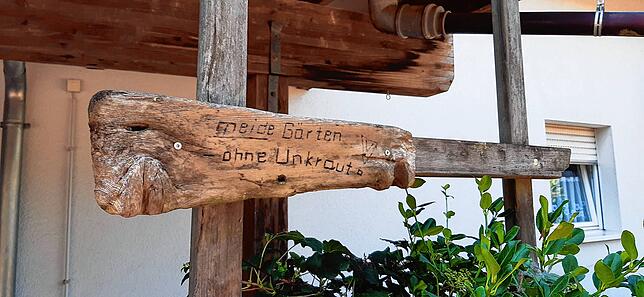 Wegweiser, der in die Richtung des Gartens von Helmut Jetter zeigt: „Meide Gärten ohne Unkraut.“