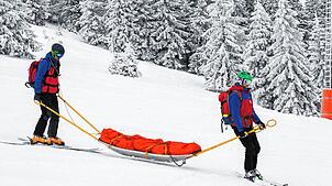 Die Bergwacht im Einsatz auf einer Ski-Piste.