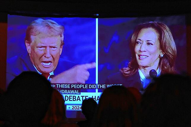 Donald Trump und Kamala Harris während der Präsidentschaftsdebatte auf einem Bildschirm in Portland
