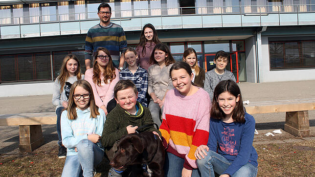 Die Schülerinnen und Schüler der Klasse 7b freuen sich mit Klassenlehrer Torsten Stock über ihren Schulhund Floki. Bild: Reiner Baltzer