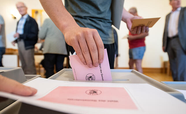 Ein Mann wirft seinen Stimmzettel für die Kommunalwahl in Baden-Württemberg ein.