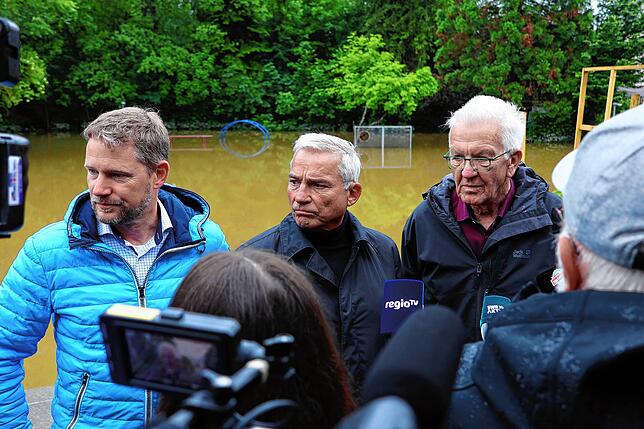 Ministerpräsident Winfried Kretschmann (rechts) und Landesinnenminister Thomas Strobl (Mitte) im Juni 2024 vor dem überschwemmten ...