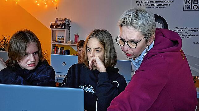 Ivan und Platon (von links) kommen beim Programmieren nicht weiter, Schulleiterin Elvina Shakhmurzaevanur hilft. Sie gibt aber lachend ...