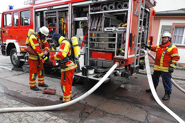 Wasser Marsch: Michael Mutter (rechts) am Görwihler Löschfahrzeug, während zwei Atemschutzträger sich auf ihren Einsatz vorbereiten.