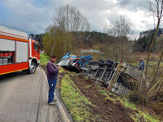 Der Lkw hatte schweres Gerät geladen. Der Anhänger kippte um, das Zugfahrzeug liegt seitlich gekippt und verkeilt im Straßengraben. Die ...