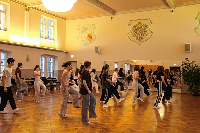 Die 18 Tänzerinnen und Tänzer wärmen sich mit einer kleinen Choreografie auf.