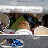 Benutzte Einweg-Kaffeebecher liegen in einem Mülleimer. Das Mehrwegsystem soll die Abfallmenge reduzieren.