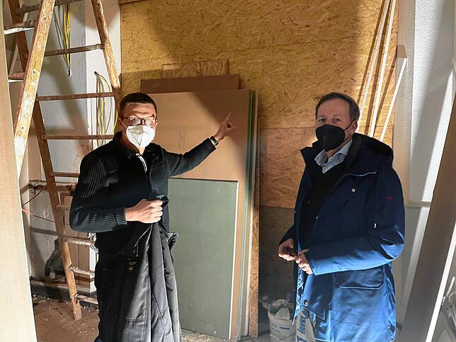 Architekt Meinhard Hansen (links) zeigt auf eine Wand, durch die es künftig Zugang vom Haupteingang zu einem Behinderten-WC im ...
