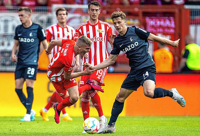 Berlins Andras Schäfer (l) geht zu Boden gegen Yannik Keitel (r) von SC Freiburg.