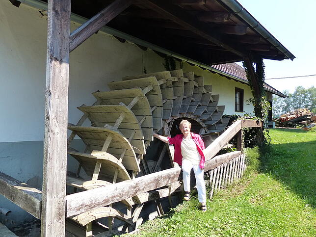 Sofie Schellinger vor dem historischen Mühlrad der Unteren Mühle, das heute noch elektrisch zum Laufen gebracht werden kann.