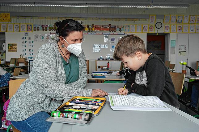 Das soziale Miteinander darf nicht auf der Strecke bleiben: Lehrerin Anne Beran unterstützt Zweitklässler Tim bei den Deutschaufgaben.