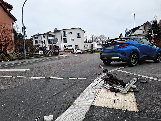Eine Radaufhängung mit einem Teil der Vorderachse liegt am Straßenrand.