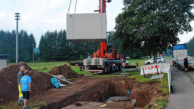 Das schwere Betonteil wird per Kran in die richtige Position gebracht. Es handelt sich um einen Druckminderungsschacht für die ...