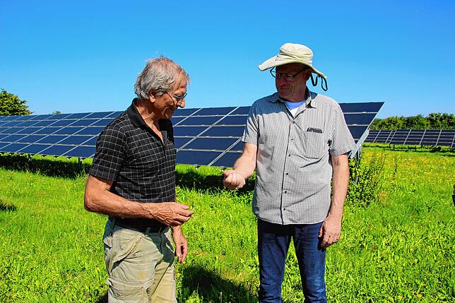 Bene Müller aus dem Vorstand von Solarcomplex zeigt Eberhard Koch (links) ein Widderchen, das er auf der Wiese gefangen hat.