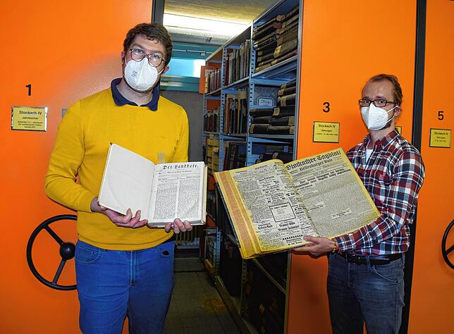 Archivleiter Johannes Waldschütz (links) und sein Mitarbeiter Christopher Wagenheim zeigen Bände verschiedener historischer Zeitungen, ...