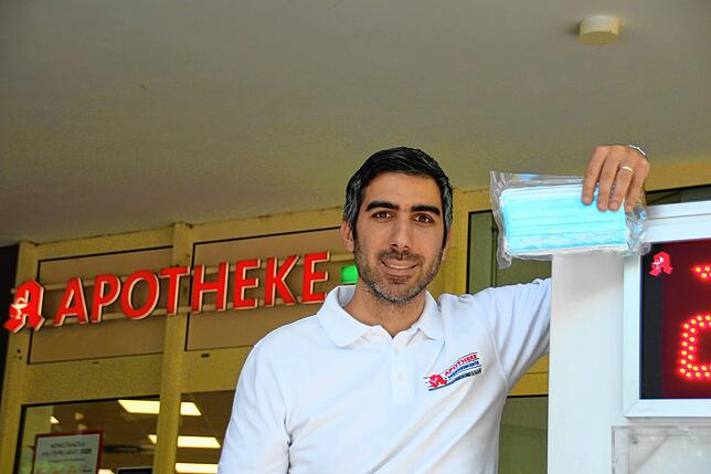 Murat Baskur zeit ein Päckchen mit Mund- und Nasenschutzmasken. Der Apotheker hat vier Lieferanten, bei denen er regelmäßig Masken ...