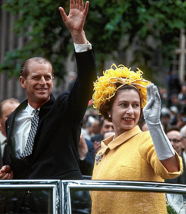 Die britische Königin Elizabeth II. und ihr Gatte Prinz Philip winken während ihrer Fahrt durch Berlin am 27.05.1965 aus einem offenen ...