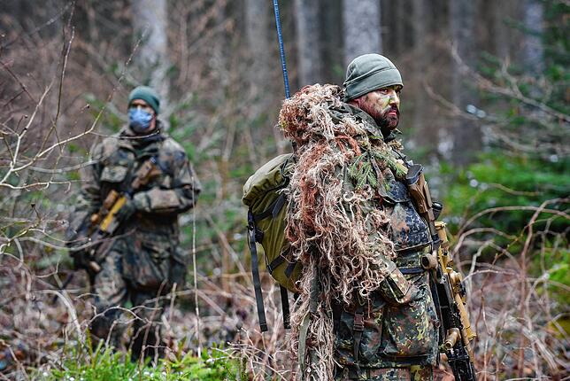 Erst als die Soldaten sich vom Waldboden erheben, sind sie zu entdecken. Mit verschiedenen Übungen wird den Gästen aus der Politik und ...