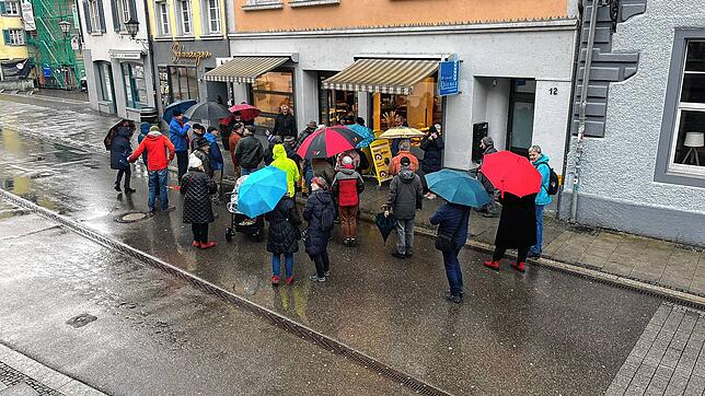 Auch bei schlechtem Wetter darf man nicht vergessen. Rund 40 Personen hört den Geschichten über die Menschen hinter den Stolpersteinen zu.