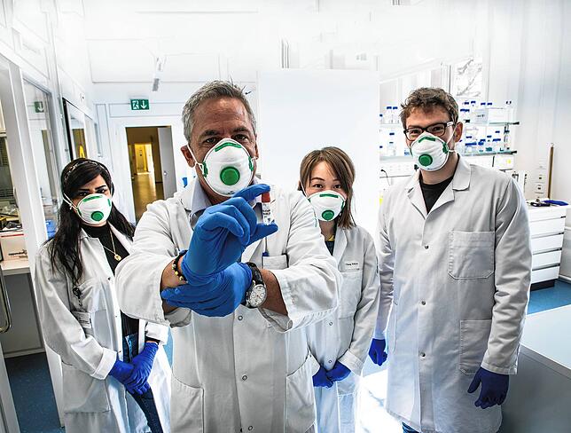 Immunologe Martin Bachmann (2. von links) mit seinem Team am Inselspital in Bern. In seiner Hand hebt er eine Ampulle mit dem von ihm ...