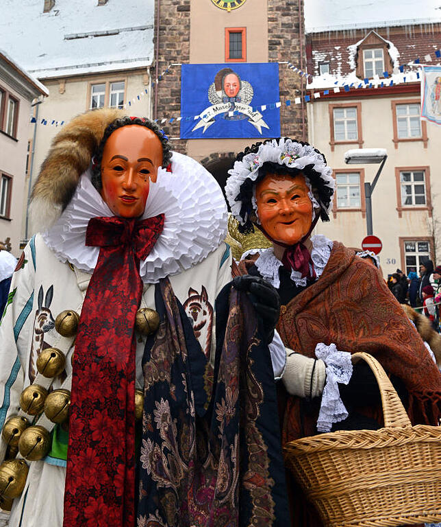 Ein Villinger Narro (l) und eine Alt-Villingerin (r), Narrenfiguren der Narrenzunft Villingen, laufen  beim grossen Fasnachtsumzug in ...
