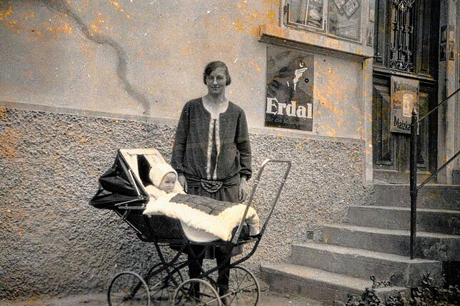 Diese Aufnahme aus dem Jahr 1928 zeigt Rosina Horn mit Tochter Erna im Kinderwagen vor dem Kolonialwarenladen, Haldenweg 2, in Leimbach.