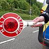 Ein Polizist hält eine Kelle, um das Anhalten zu signalisieren.