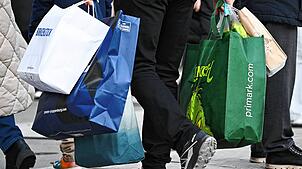 Ein Mann geht mit Tüten bepackt über die Einkaufsstraße Zeil.
