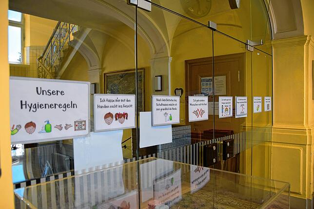 Hinweistafeln weisen die Schüler auf die geltenden Corona-Regeln hin.