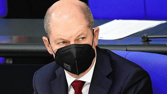 Bundeskanzler Olaf Scholz verfolgt die Rede des CDU-Bundesvorsitzenden Merz während der Sondersitzung des Bundestags zum Krieg in der ...