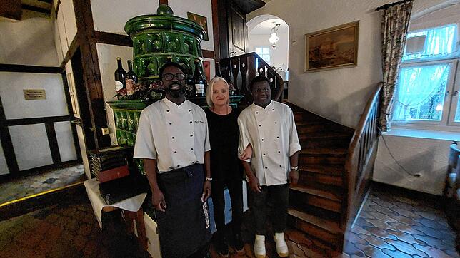 Annerose Gurlitt mit ihren Köchen Pierre Hilaire (links) und Tijan Dibba vor dem Ofen des Gastraumes. Rechts geht es die Treppe hinauf ...